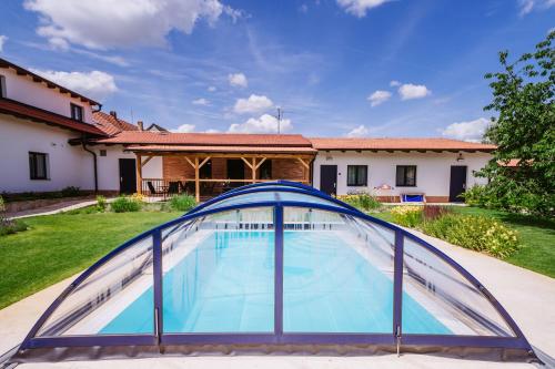 a swimming pool in a yard with a blue roof at Pod humnama in Krumvíř