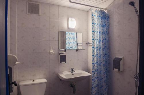 y baño con aseo blanco y lavamanos. en хотел Русалка, en Varna