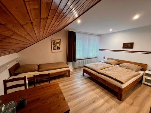 a bedroom with two beds and a wooden ceiling at Casa Milix - Bed & Breakfast in Winterberg