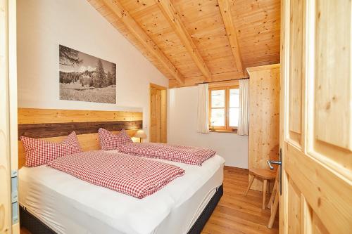 a bedroom with a bed with red and white pillows at Landhauswohnung Dosbach in Reit im Winkl