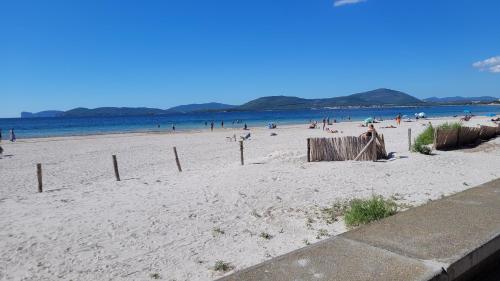 a beach with a bunch of people on it at Actinia Accommodation in Alghero