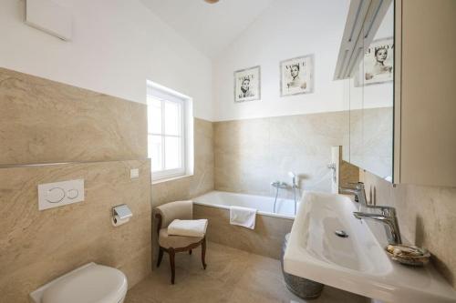 a bathroom with a sink and a tub and a toilet at Loft “Samuel” in Utting am Ammersee