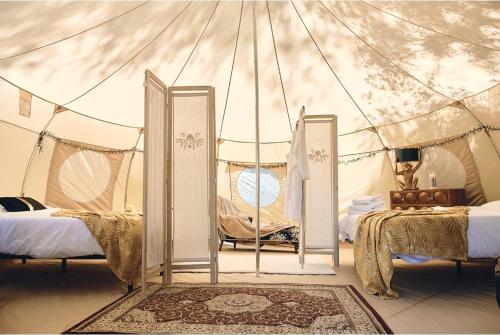 Margouët-Meymès的住宿－Camping d'artagnan，一间帐篷内带两张床的卧室