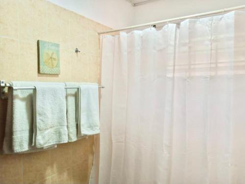a bathroom with a white shower curtain and towels at Marrets International Hotel - "Express" in Cape Coast