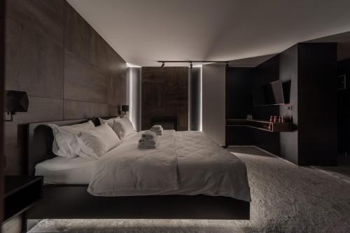 um quarto com uma cama grande e lençóis brancos em Rei House Apartmani em Belgrado