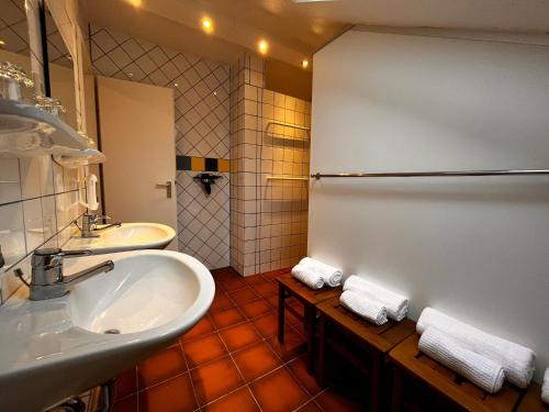 ein Badezimmer mit einem Waschbecken, einem Spiegel und Handtüchern in der Unterkunft Casa Milix - Bed & Breakfast in Winterberg