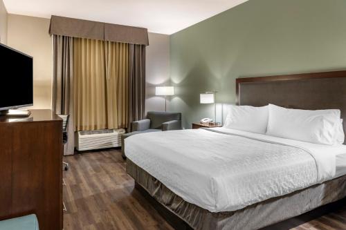 a hotel room with a bed and a flat screen tv at Holiday Inn Express & Suites Indio - Coachella Valley by IHG in Indio
