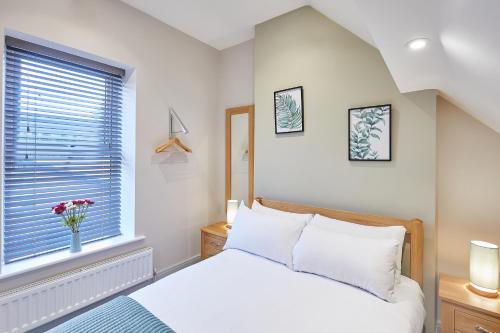 a bedroom with a white bed and a window at Host & Stay - Ramblers Retreat in Pateley Bridge