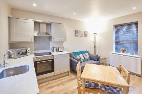 a kitchen and living room with a couch and a table at Host & Stay - Ramblers Retreat in Pateley Bridge
