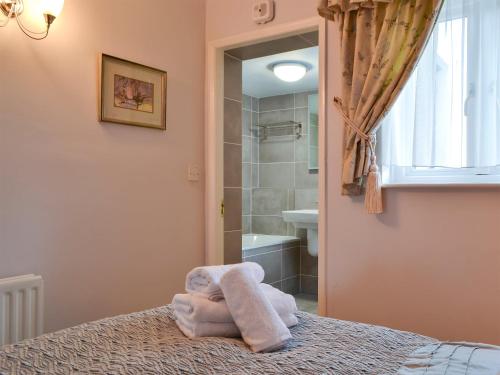 a bedroom with a bed and a bathroom with a shower at Eskdale in Ambleside