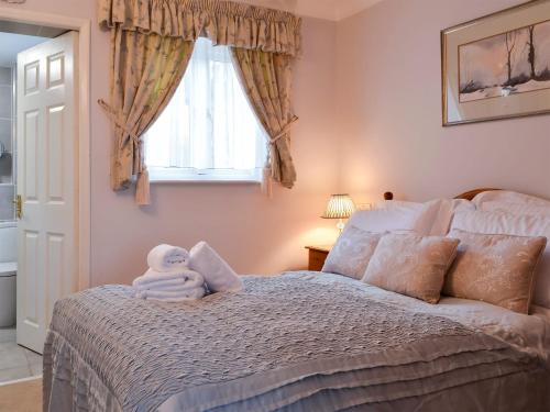 a bedroom with a bed with a towel on it at Eskdale in Ambleside