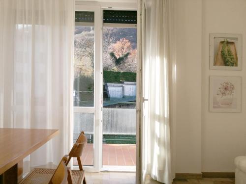 Cette chambre dispose d'une grande fenêtre avec des rideaux blancs. dans l'établissement Casa di Wheeny, à Côme