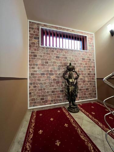 a statue in front of a brick wall with a window at PENSIUNEA UNO in Timişoara
