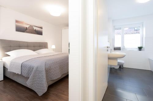 a bedroom with a bed and a bathroom with a sink at Strandstraße 42 Strandidyll 3 in Niendorf