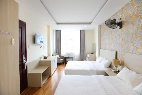 une chambre d'hôtel avec deux lits et une chaise dans l'établissement TTR Vincent Hotel, à Đà Lạt