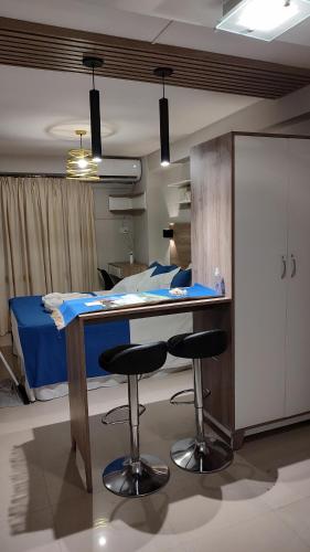 ein Krankenhauszimmer mit einem Tisch und zwei Barhockern in der Unterkunft Zafiro Barrio Norte by Citrino Aparts in San Miguel de Tucumán