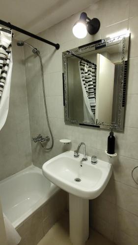 W łazience znajduje się umywalka, lustro i wanna. w obiekcie Zafiro Barrio Norte by Citrino Aparts w mieście San Miguel de Tucumán