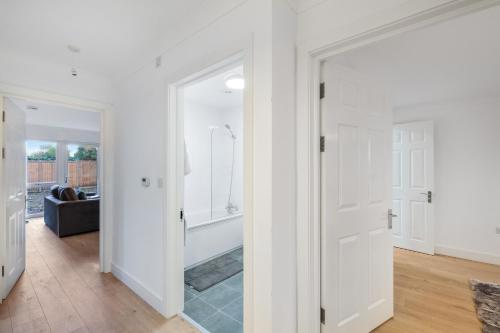 un pasillo con una puerta que conduce a una sala de estar en Pinewood Studios, Iver Slough Heathrow 1 & 2 Bedroom Apartments with Parking by Arista Living, en Slough
