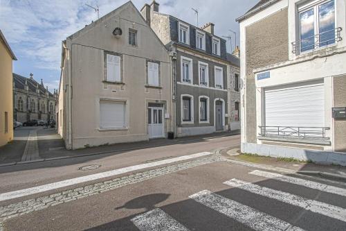 an empty street with some buildings and a building with a garage at MIMALELY - House & terrace in Isigny-sur-Mer