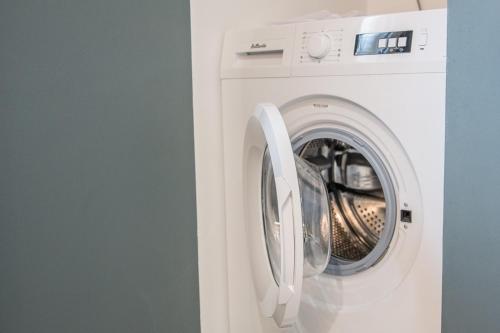 a white washing machine sitting in a room at MIMALELY - House & terrace in Isigny-sur-Mer