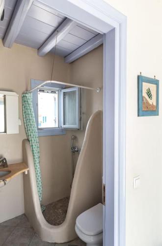 a bathroom with a shower and a toilet in a room at 'Nepheli' Mykonean Suite in Ornos