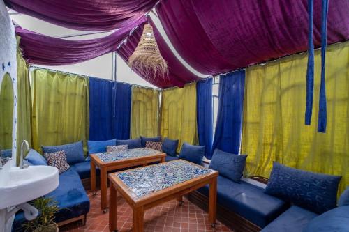 um quarto com um sofá e mesas numa tenda em Riad Mosaic em Chefchaouene