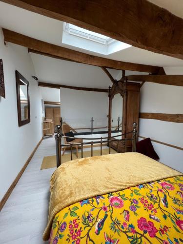 een slaapkamer met een bed en een tafel in een kamer bij Virolet Barn in Queaux