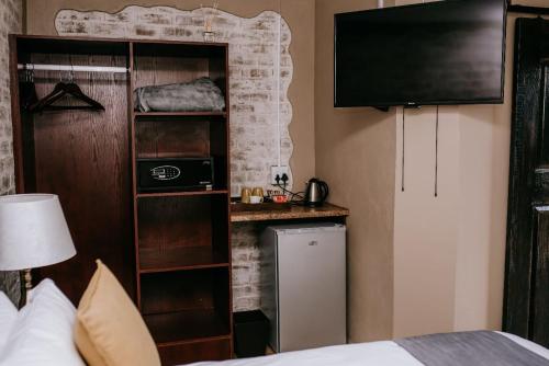a hotel room with a bedroom with a bed and a television at La Bendicion in eMalahleni