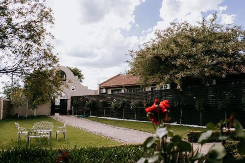 a yard with chairs and a fence and a house at La Bendicion in Witbank