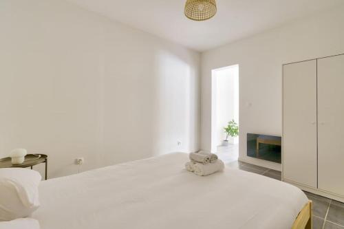 um quarto branco com uma cama grande e uma televisão em Lovely apartment located 10 min from the sea side em Marselha