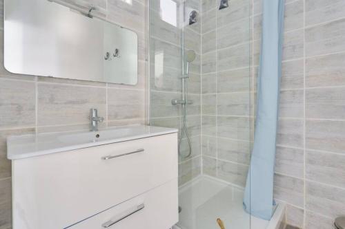 uma casa de banho com um lavatório branco e um chuveiro em Lovely apartment located 10 min from the sea side em Marselha