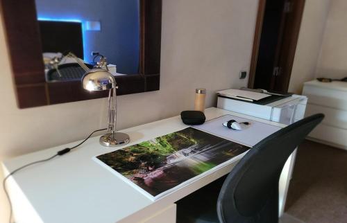 un escritorio con una lámpara y una foto en él en Palacio San Facundo en Segovia