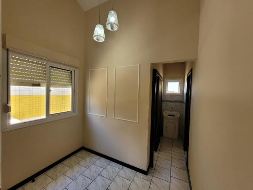 a hallway with a room with a toilet and a window at Pousada Genoveva - Apto com um dormitório in Farol de Santa Marta