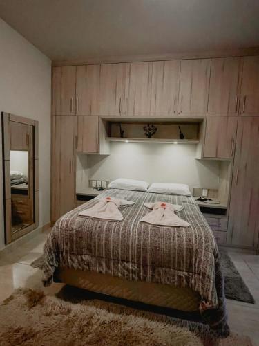 a bedroom with a bed with two robes on it at Apartamento Girassol love in Monte Verde