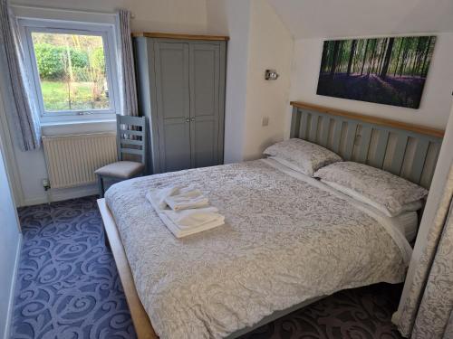 a bedroom with a bed with two towels on it at Landing Cottage Guest House in Newby Bridge