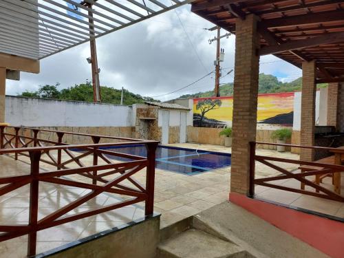 ein Haus mit einem Pool und einem Zaun in der Unterkunft Pousada Fernandes in Aratuba