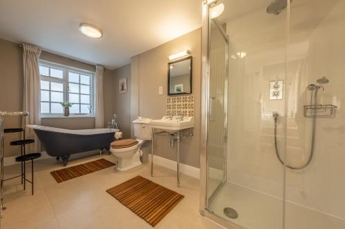 a bathroom with a tub and a toilet and a sink at Bell Tower Cottage in Middleton