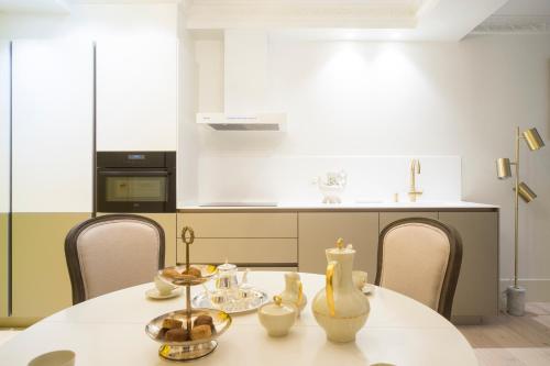 a kitchen with a white table with chairs and a counter at Brand New I Beachfront I 3 min Old Town ANVERS in San Sebastián