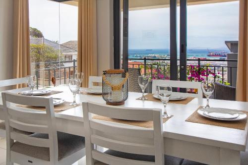 a dining room with a table and chairs with a view of the ocean at STAR APARTMENTS in Cape Town