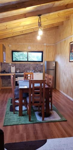 a kitchen and dining room with a table and chairs at Cabañas P y R los canelos in Hornopiren