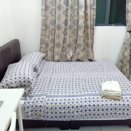 a bed with a blue and white comforter on it at jm in Shah Alam