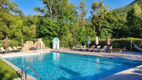 - une piscine avec chaises longues et parasols dans l'établissement Chanteduc, à Beaurières