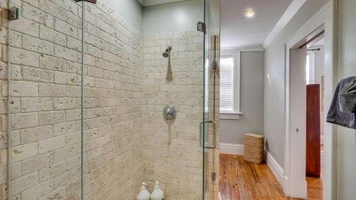 y baño con ducha de cristal y pared de ladrillo. en 201 York #3 · Homey Downtown 2 Bedroom Steps from the River en Savannah