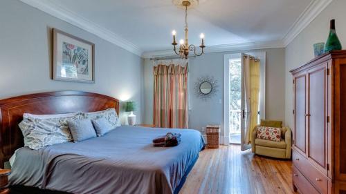 a bedroom with a large bed and a chair at 201 York #3 · Homey Downtown 2 Bedroom Steps from the River in Savannah