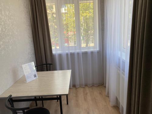a table and chairs in a room with windows at Готель «У Батька» in Truskavets