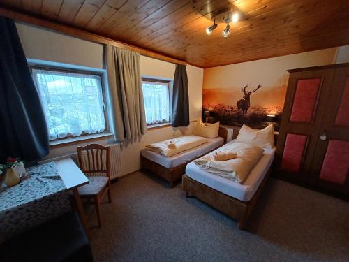 a hotel room with two beds and a table and window at Chalet Auhof Flachau in Flachau