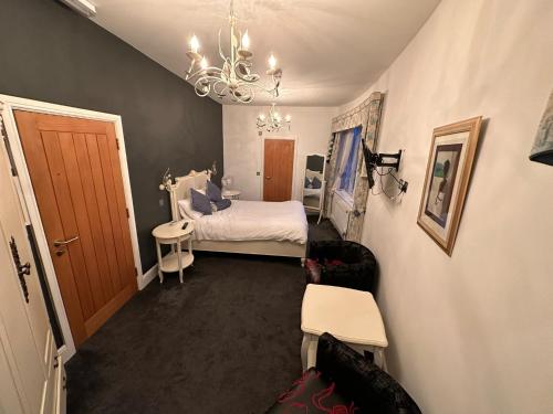 a small bedroom with a bed and a chandelier at The Vernon in Droitwich