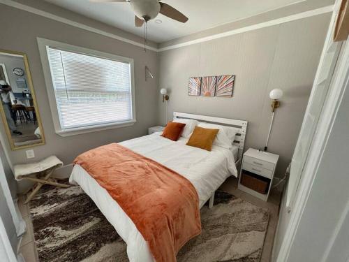 ein Schlafzimmer mit einem Bett mit einer orangefarbenen Decke und einem Fenster in der Unterkunft The Mini Coconut in Marathon