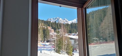 a window with a view of a ski resort at Appartamento a Madonna di Campiglio in Madonna di Campiglio