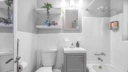 a white bathroom with a toilet and a sink at Cozy 1 BDR Unit by Beach, Mall, & Downtown FTL in Fort Lauderdale